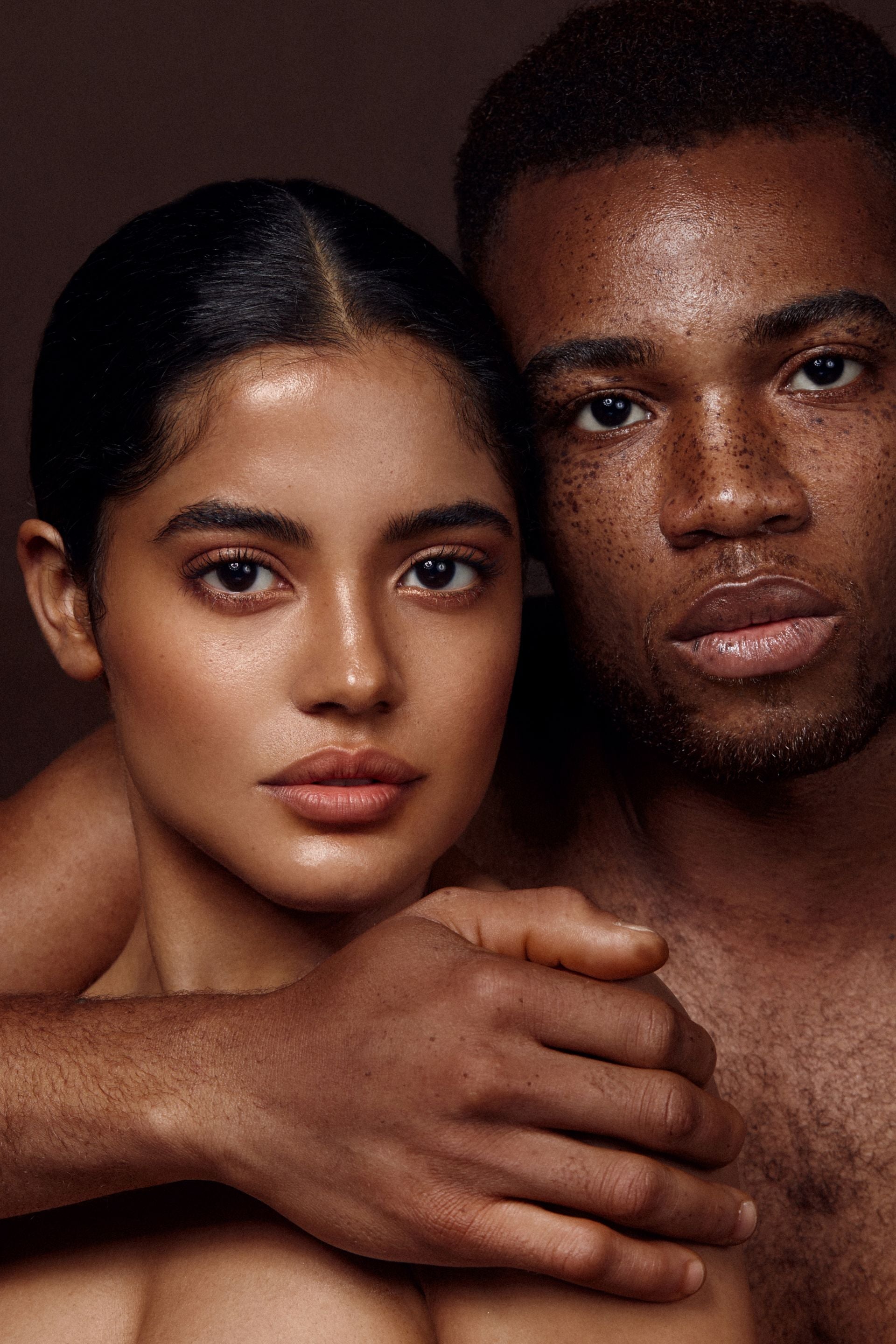 ein paar posiert sich umarmend vor der Kamera.