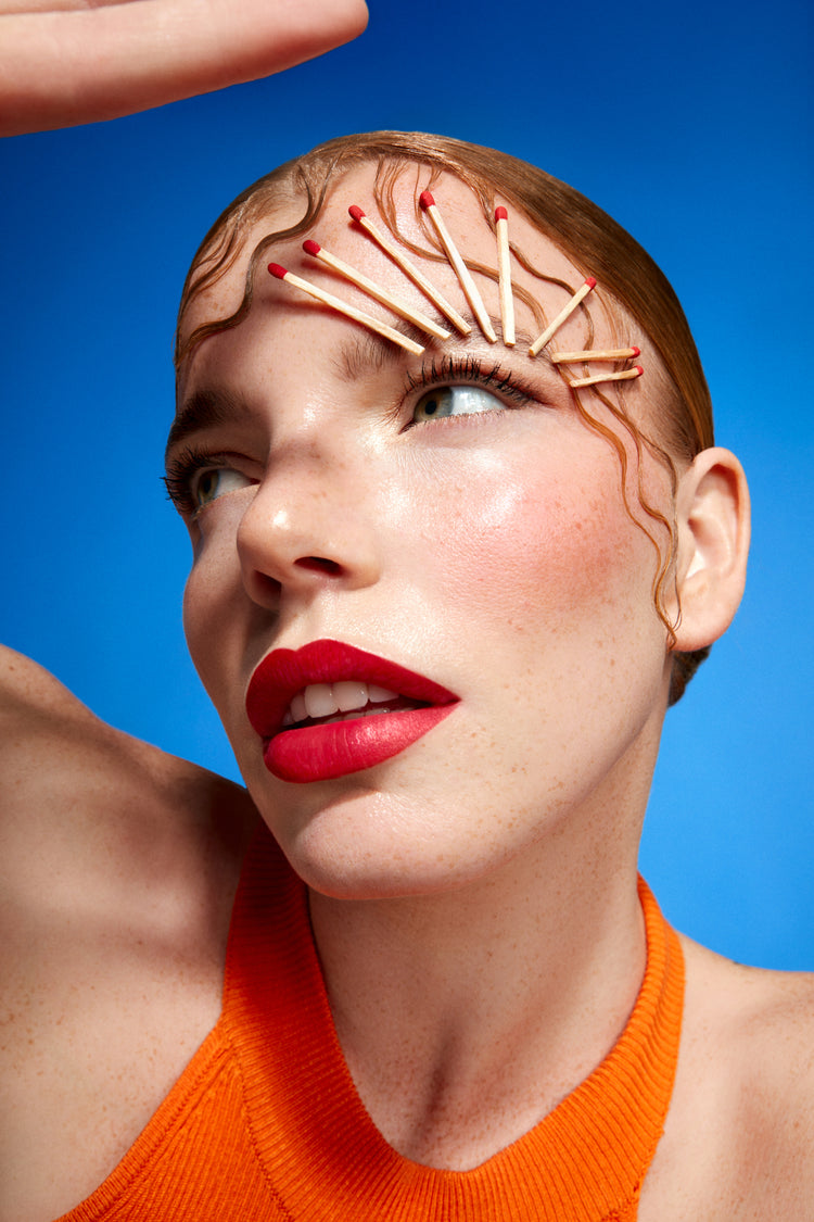 Model mit Zündhölzern auf dem Gesicht