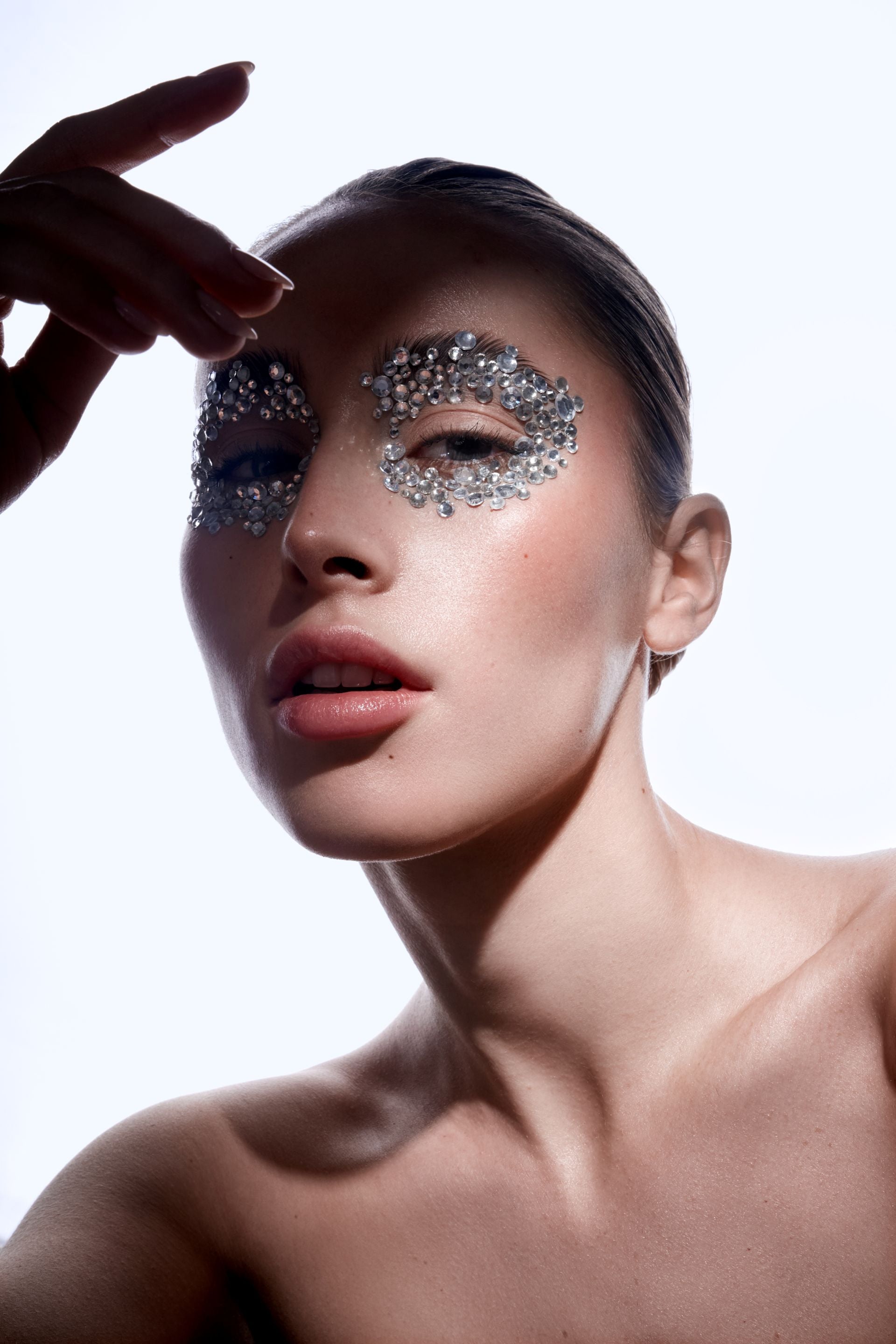 Blonde Frau mit Strasssteinen um die Augen.