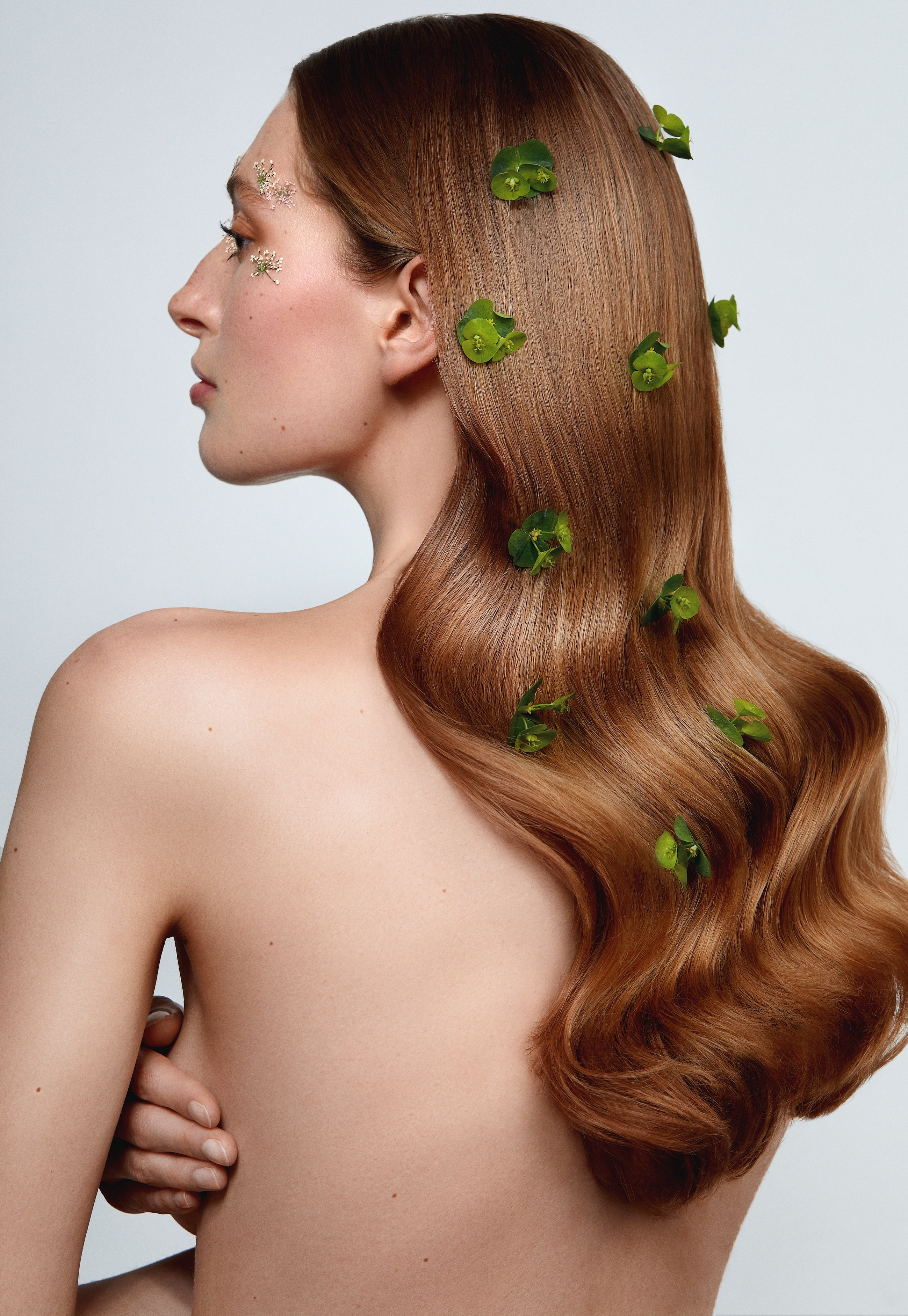 Model mit langem welligen Haar und Blüten.