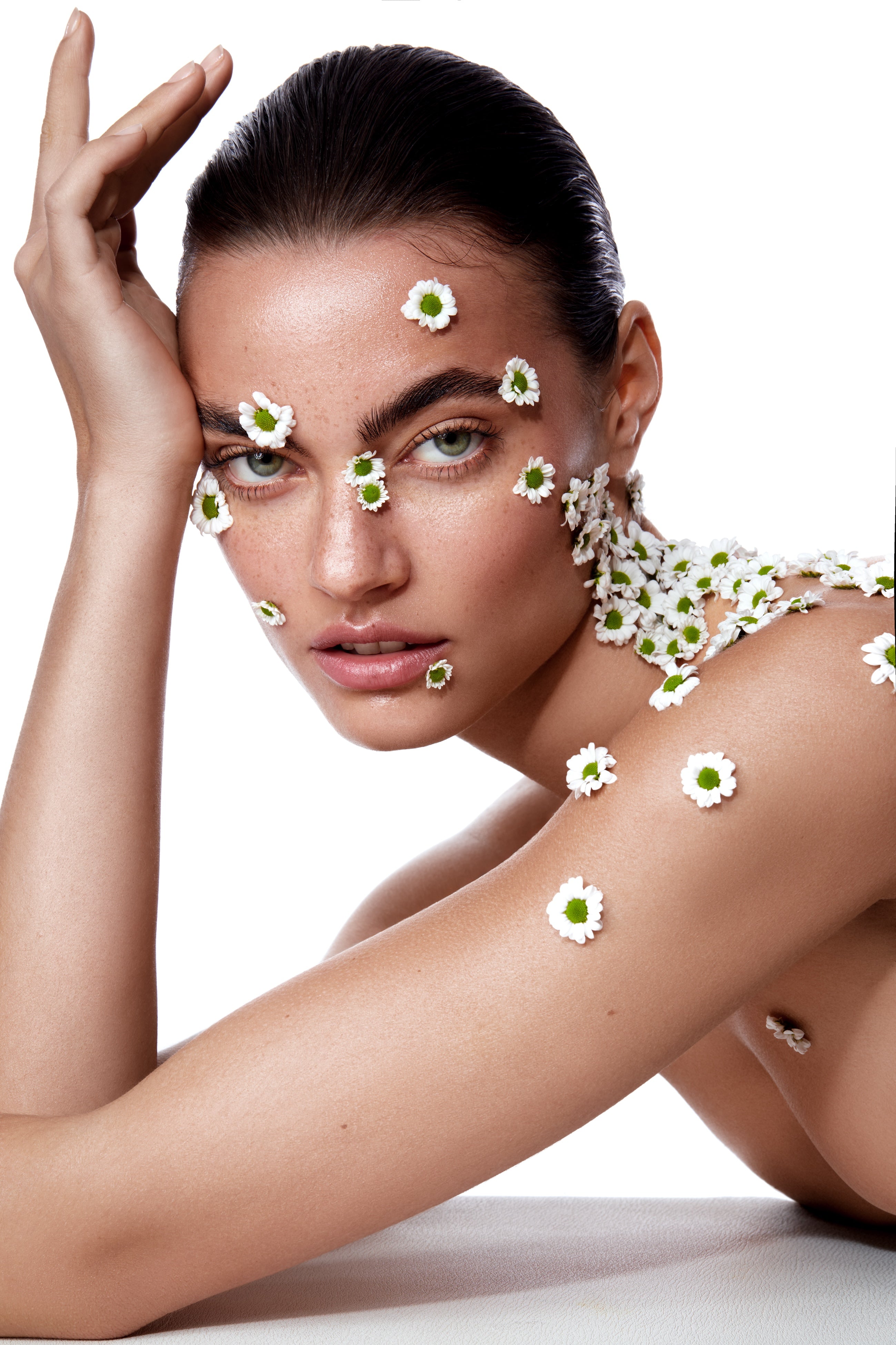 Model mit Nude Makeup und Blütenapplikationen