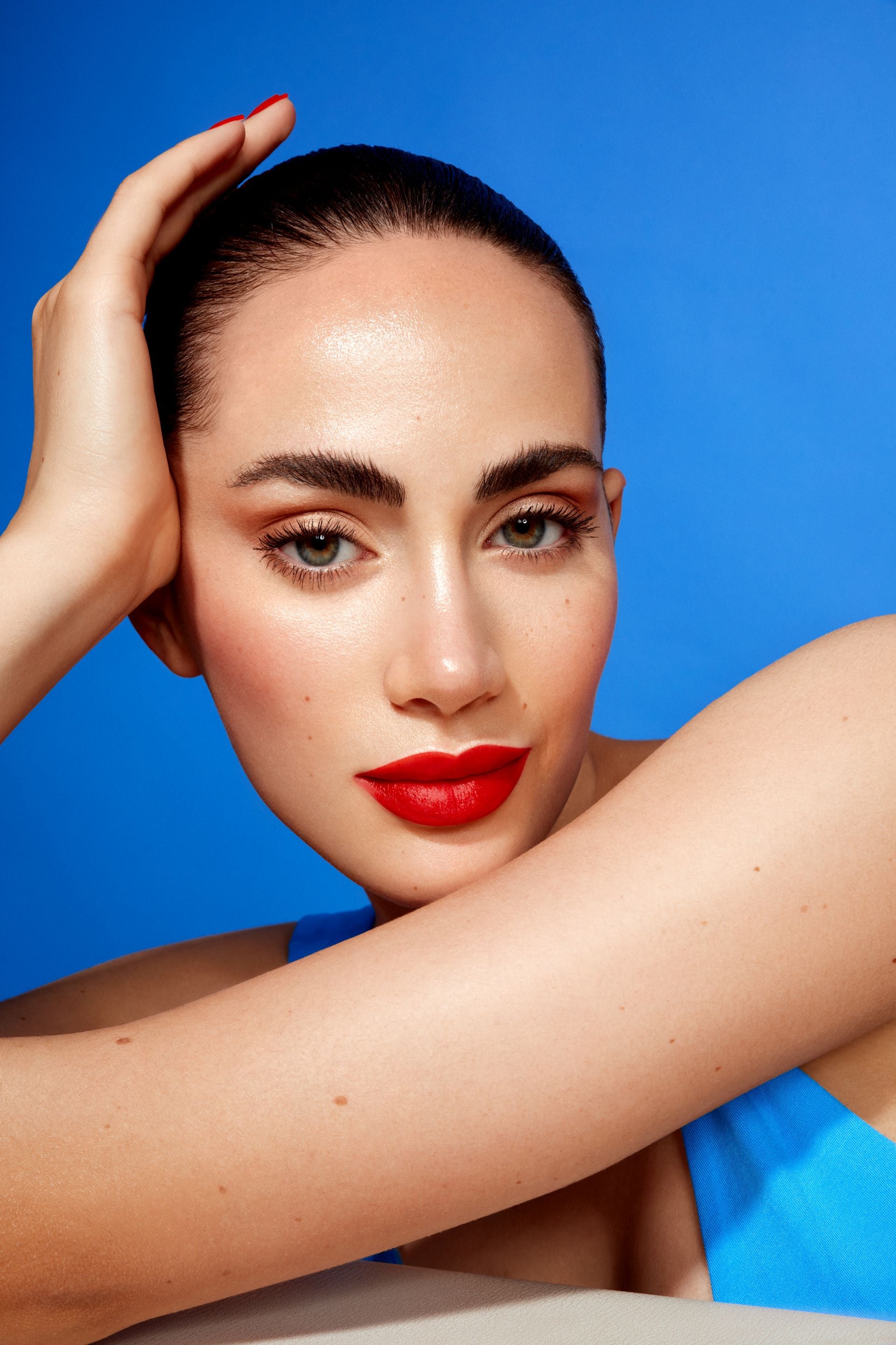 Frau. mit roten Lippen vor blauem Hintergrund