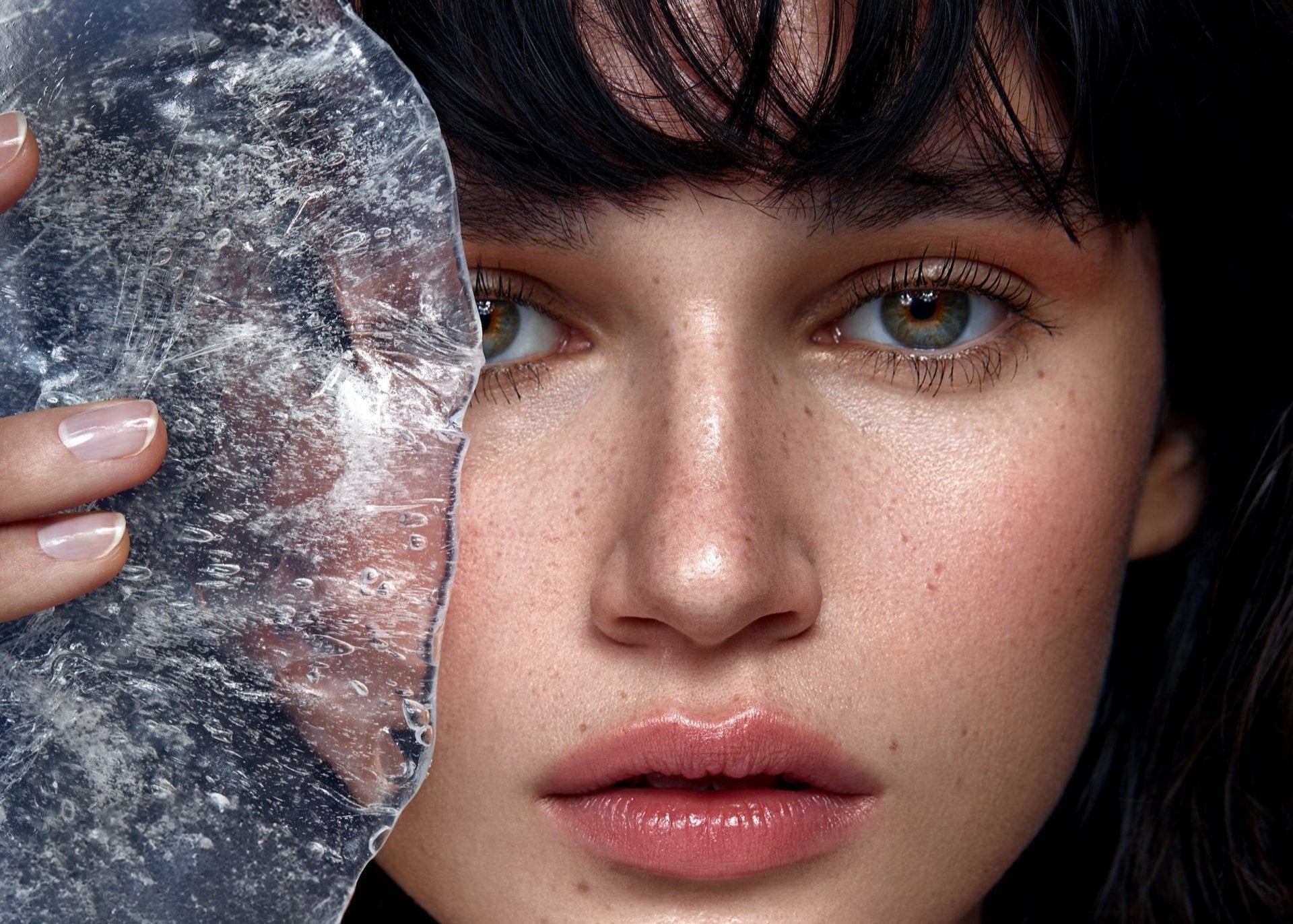 Frau mit Eis in der Hand und dunklen Haaren mit Nude Makeup Look